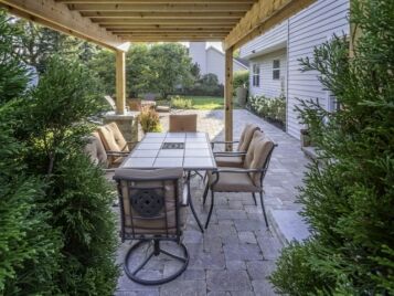 PetrovicImagery_Apex_AdlerDr-2-scaled Pergola-covered paver patio with outdoor dining set — Apex Landscaping