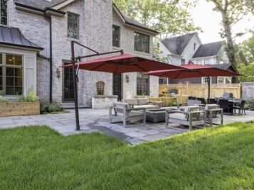 PetrovicImagery_Apex_Asbury-9 Paver patio with fire pit seating and dining area behind an estate home — Apex Landscaping