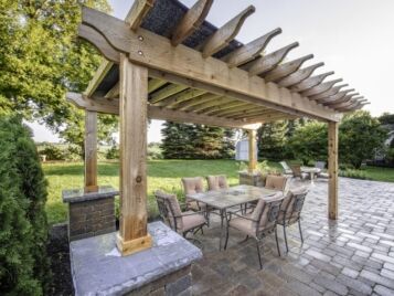 PetrovicImagery_Apex_AdlerDr-4-1-scaled Cedar pergola over a paver patio with an outdoor dining set — Apex Landscaping