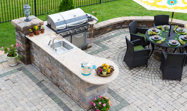 Outdoor kitchen and dining table on a paved patio