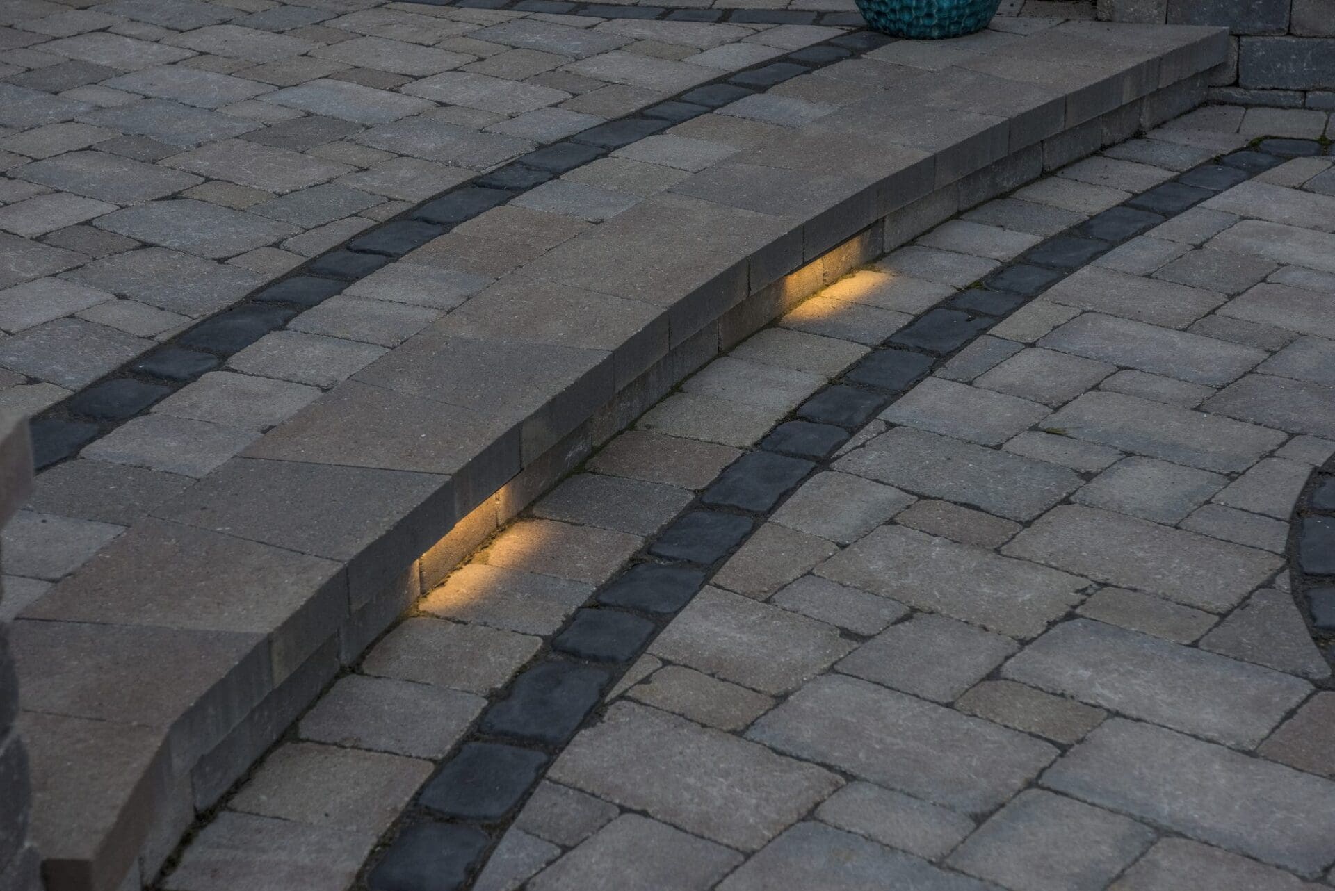 Curved paver steps with integrated landscape lighting — Apex Landscaping