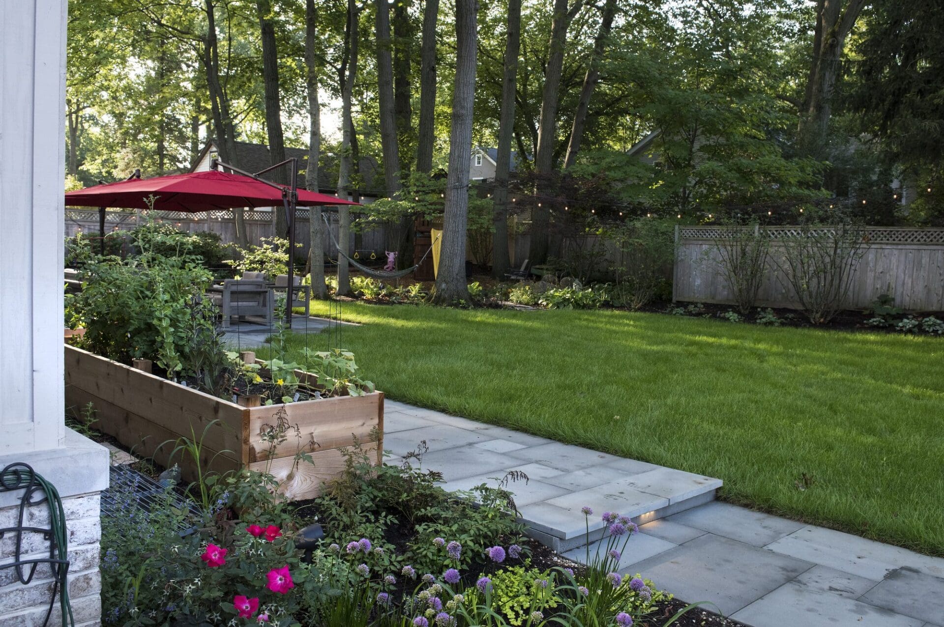 Raised planter beds beside a manicured lawn and patio — Apex Landscaping
