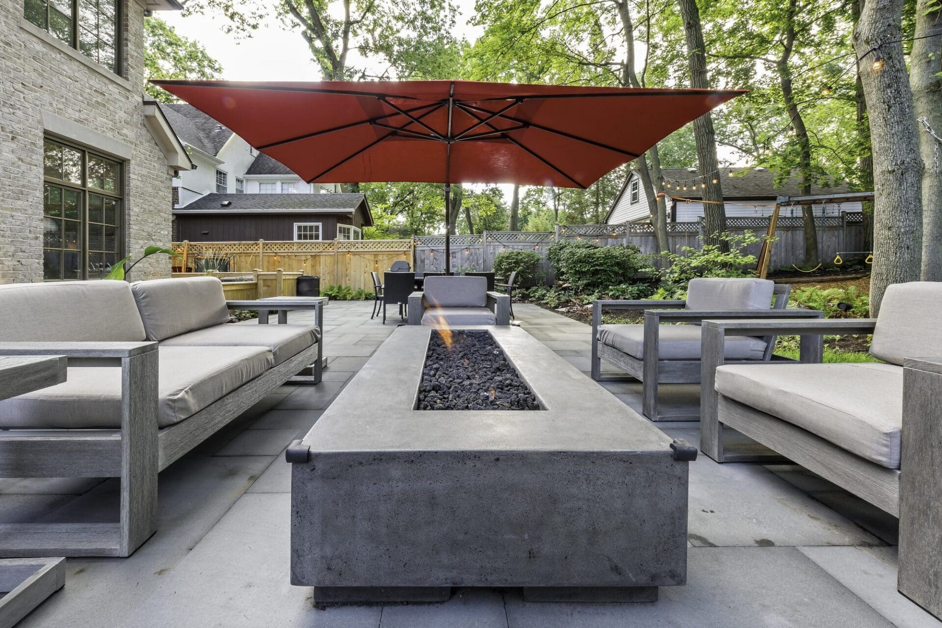 Modern linear fire feature with a patio sectional — Apex Landscaping design-build