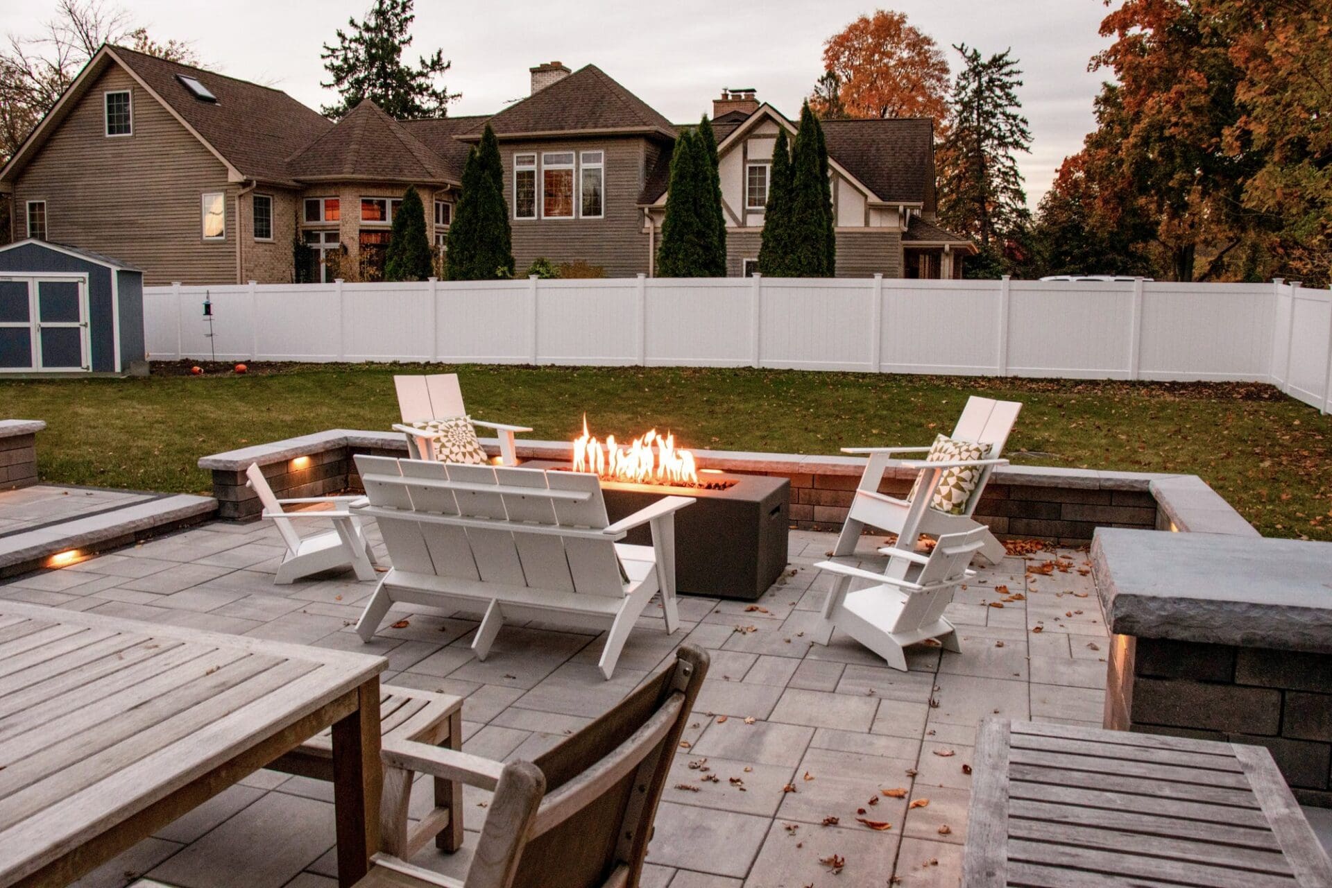 Fire pit with Adirondack chairs in autumn — Apex Landscaping design-build