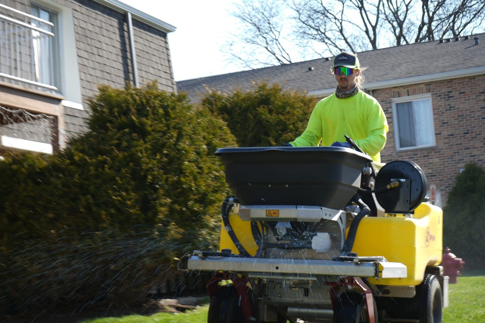 Ride-on applicator treating a commercial lawn — Apex Landscaping