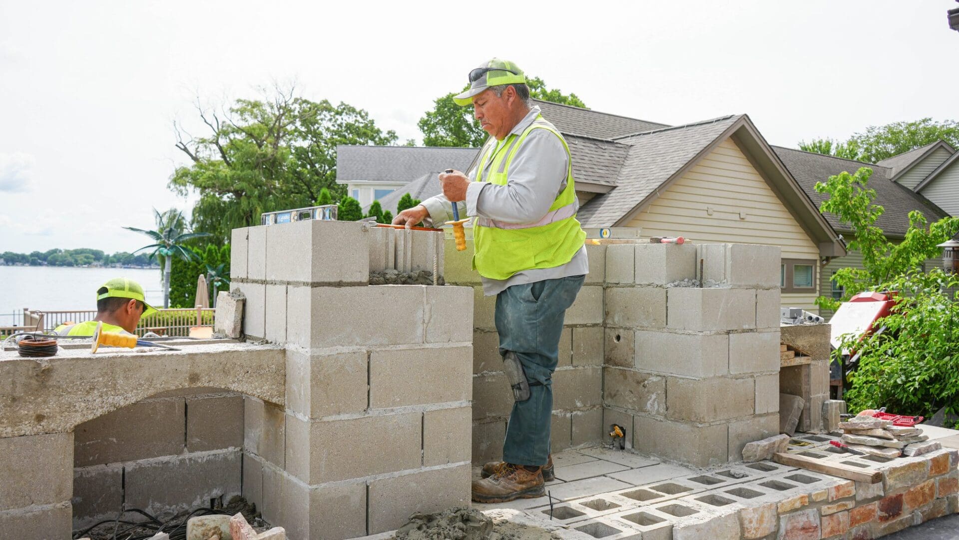 Outdoor brick fireplace under construction — Apex Landscaping design-build