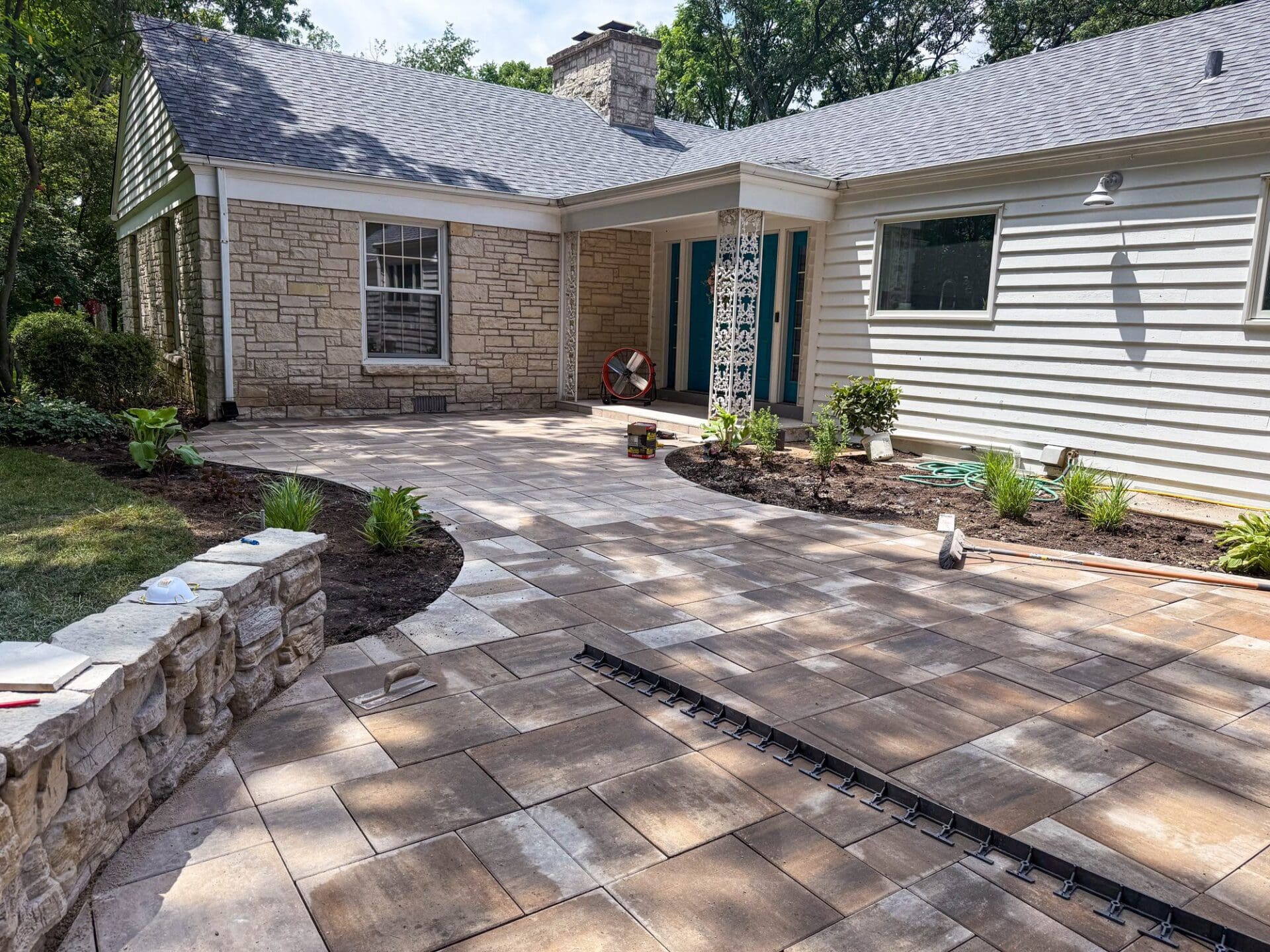 Finished paver walkway with a retaining wall — Apex Landscaping