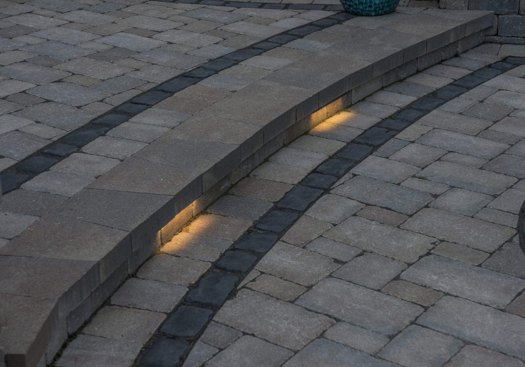 Curved paver steps with integrated landscape lighting — Apex Landscaping